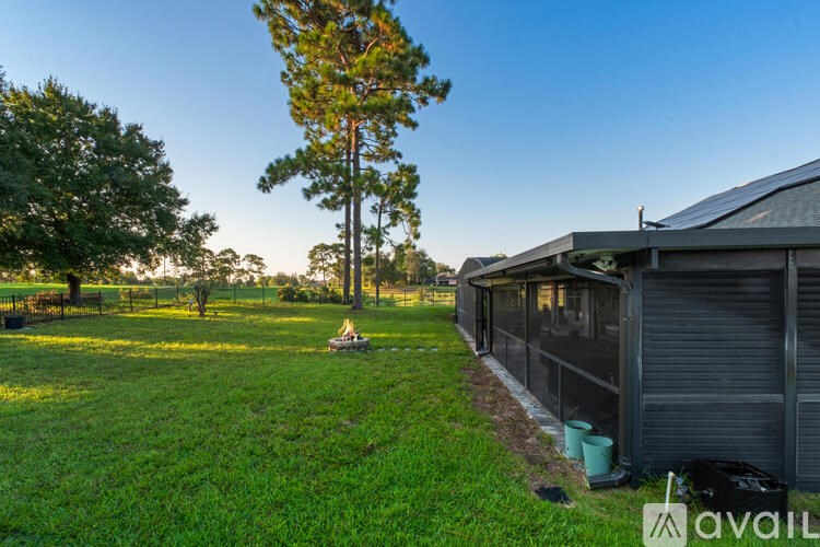 A house with a green lawn and a tree in the background.