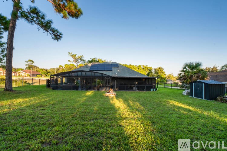 A house with a black roof and a large lawn in front.