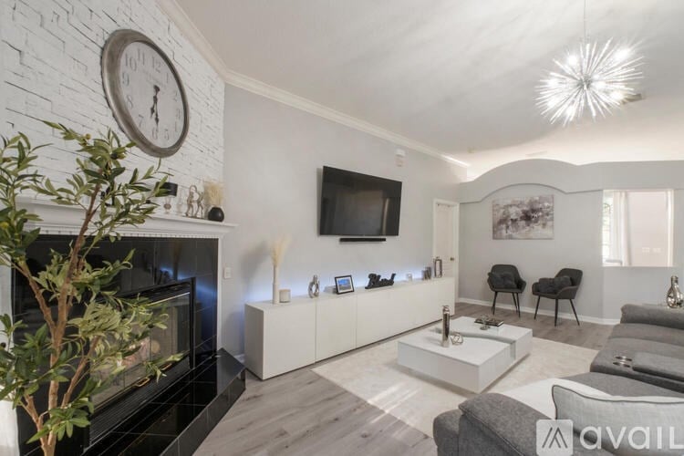 A living room with a fireplace and a television on the wall.