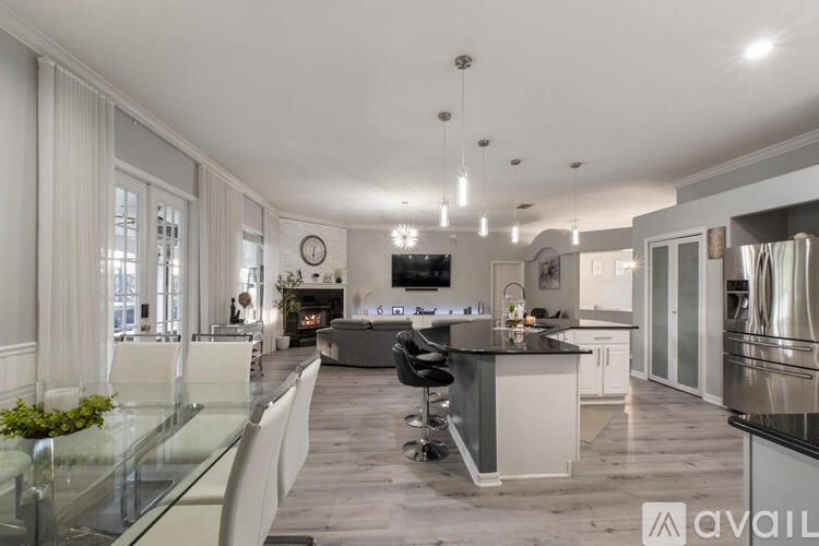 A modern kitchen with a glass table and stainless steel appliances.