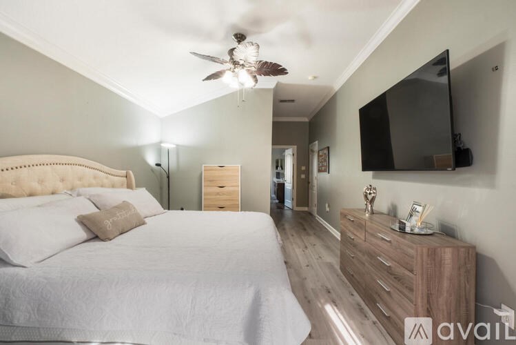 A bedroom with a large bed and a flat screen TV mounted on the wall.