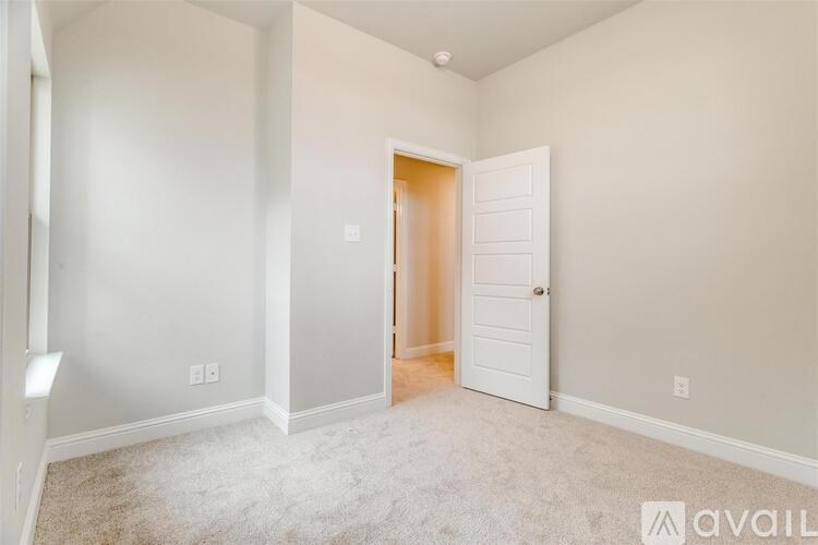 A room with a white door and carpeted floor.
