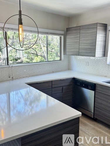 A modern kitchen with a large island and a dishwasher.