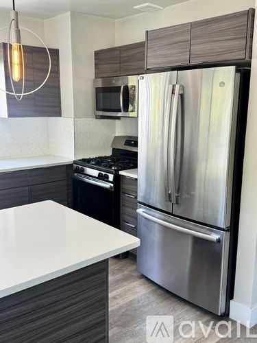 A modern kitchen with a stainless steel refrigerator and microwave.