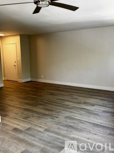 A room with a wooden floor and a ceiling fan.