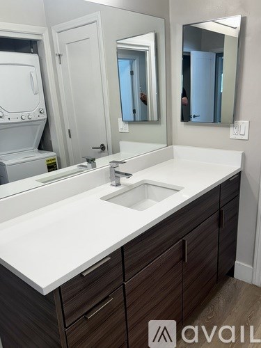 A bathroom with a sink, mirror and cabinets.
