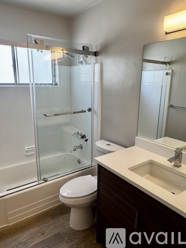 A bathroom with a toilet, sink, and shower.