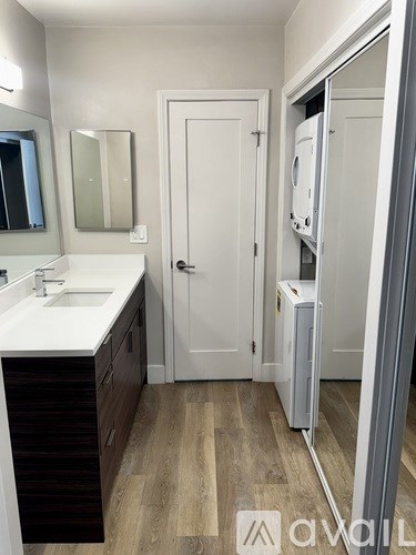 A bathroom with a sink, mirror, and a white door.