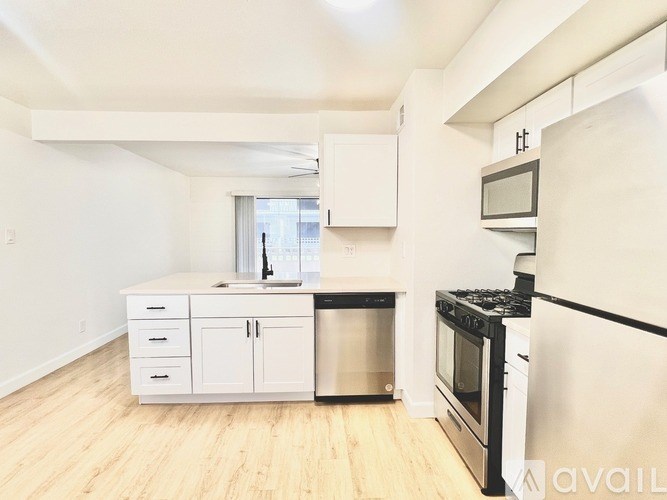A kitchen with white cabinets and black appliances.