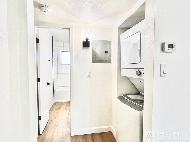 A small white bathroom with a toilet, sink, and mirror.