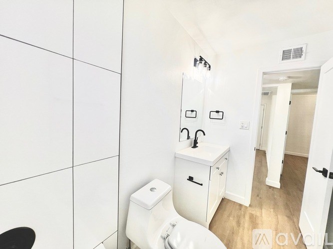 A white toilet with a white cabinet above it in a bathroom.
