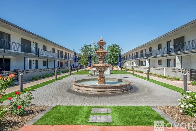 A fountain in the middle of a courtyard surrounded by buildings.