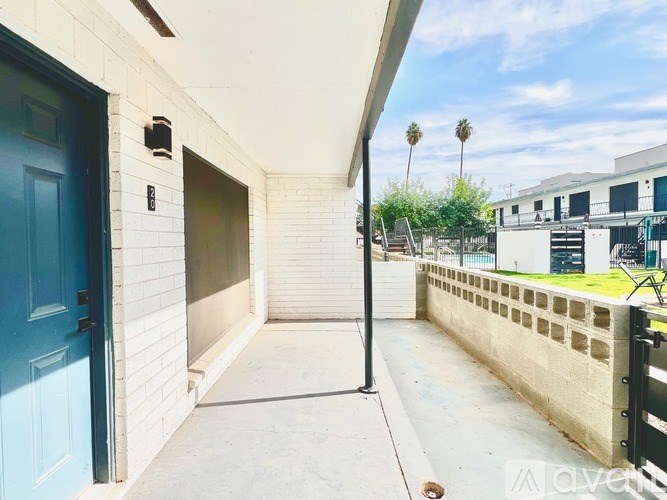 A blue door is on the left side of a white building.