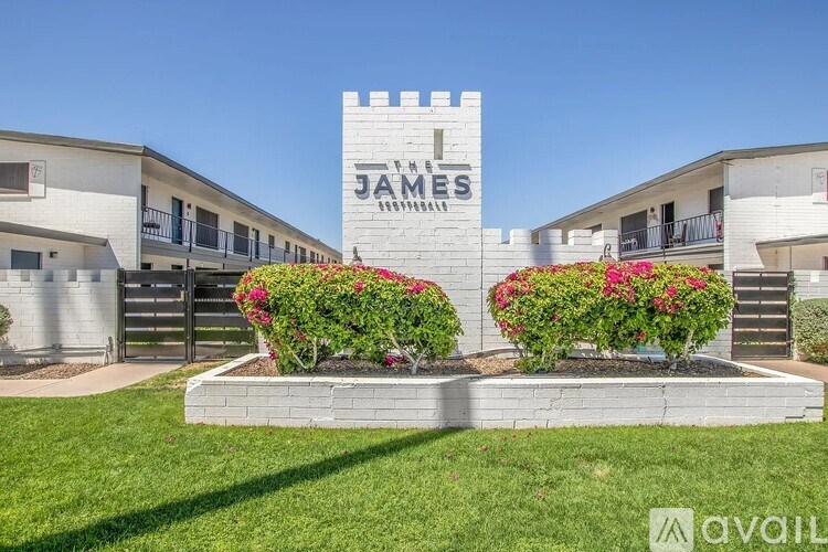 A sign that says James is in front of some buildings.