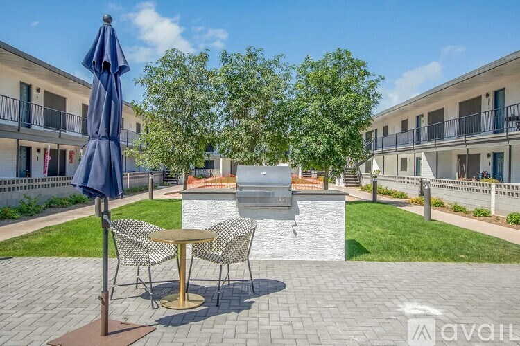 A patio area with a table, chairs, and an umbrella.
