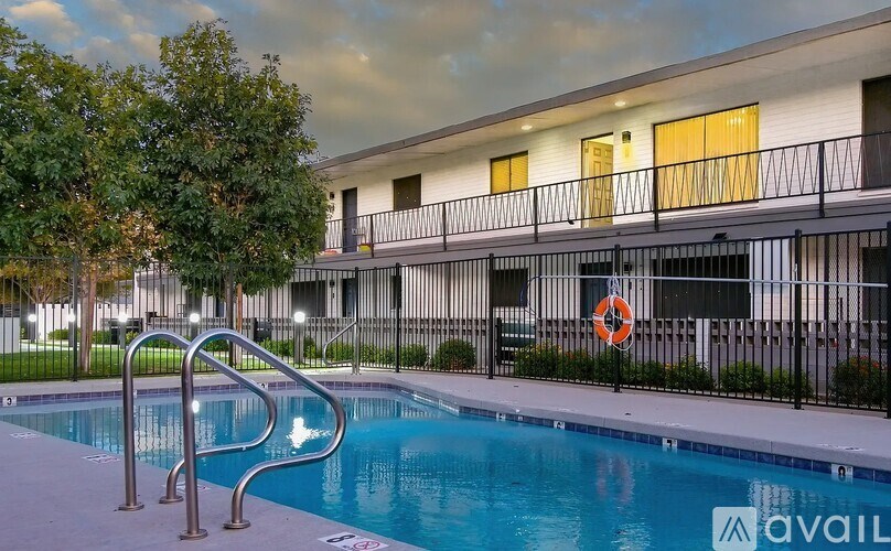 A pool with a slide and a building in the background.