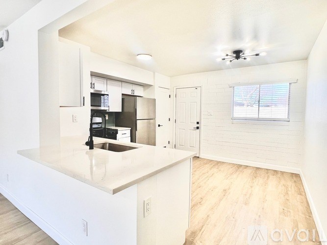 A kitchen with white cabinets and a countertop with a sink.