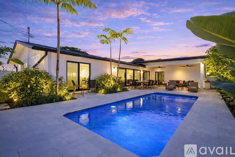A pool surrounded by green plants at night.