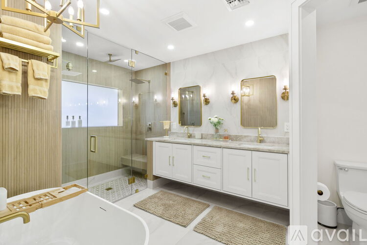 A modern kitchen with white cabinets and a marble island.