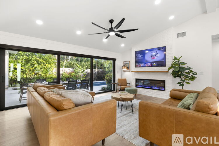 A modern living room with a large sofa and a wooden chair.