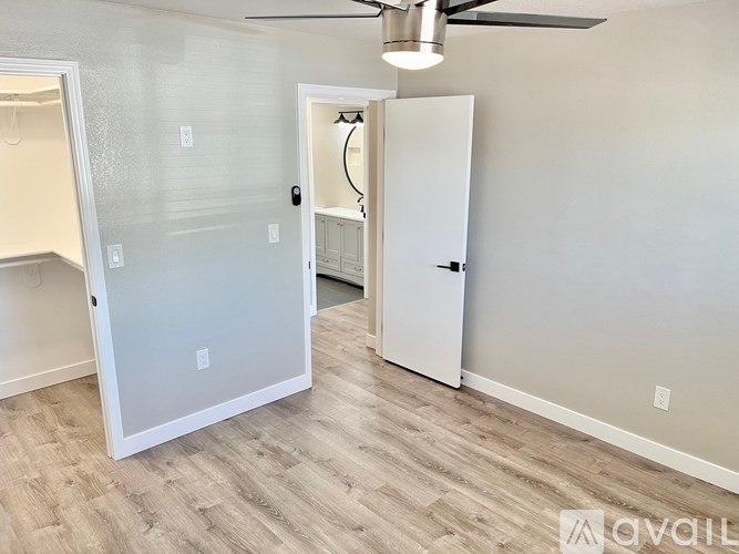 A room with a white door and a white closet with a hanger.