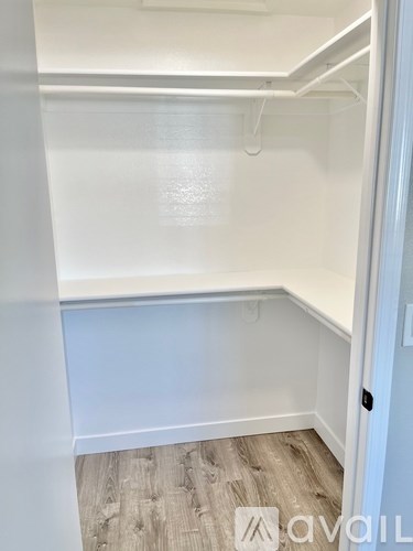 A white refrigerator with a door open in a room with wood flooring.