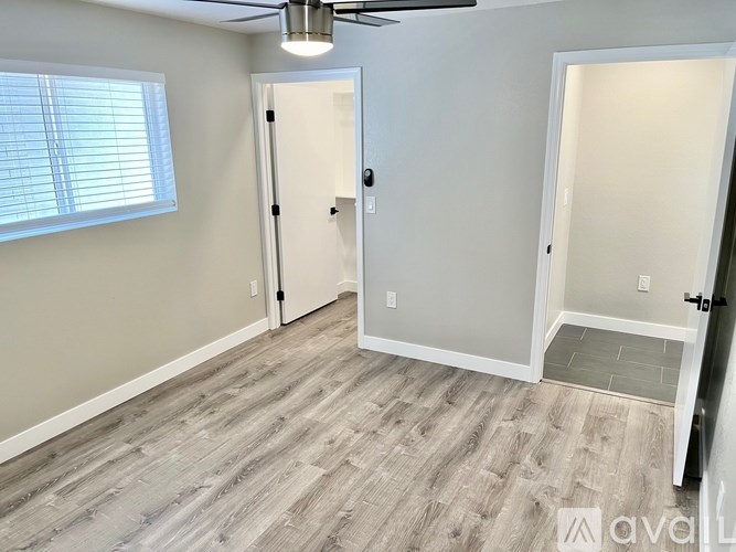 A room with a wooden floor and a ceiling fan.