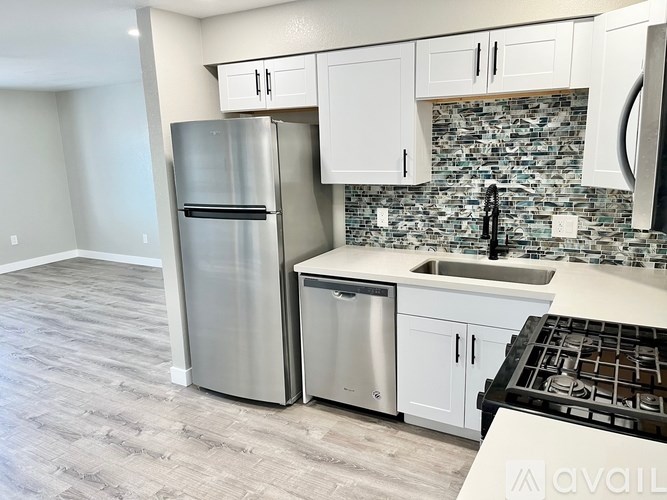A kitchen with a stainless steel refrigerator, dishwasher, and oven.