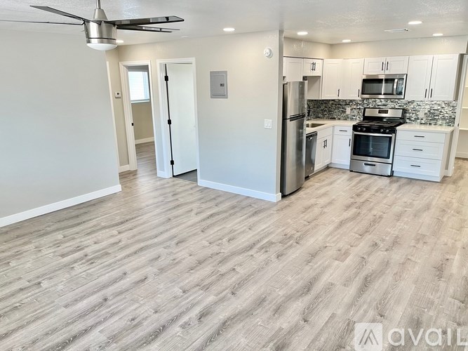 A kitchen with white cabinets and a wood floor.
