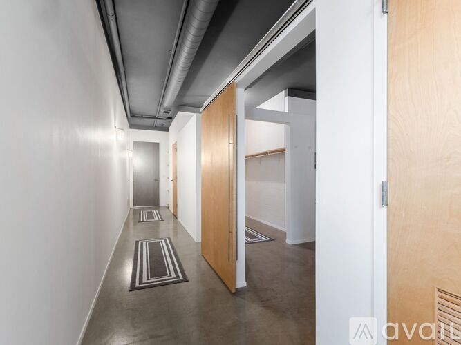 A hallway with wooden doors and a grey floor.