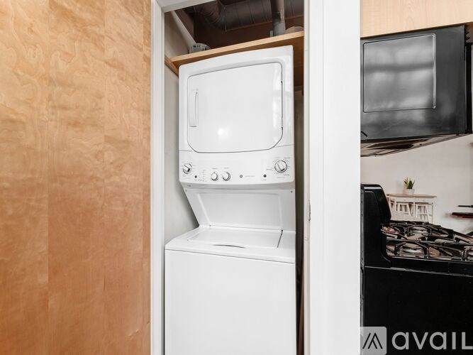 A white dishwasher is in a kitchen next to a stove.