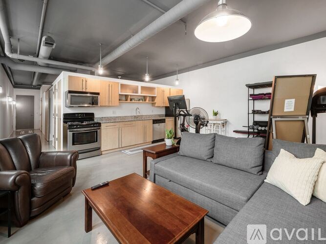 A living room with a grey couch, brown leather chair, and a wooden coffee table.