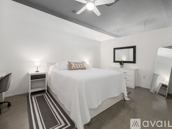 A bedroom with a bed, nightstand, and chair.