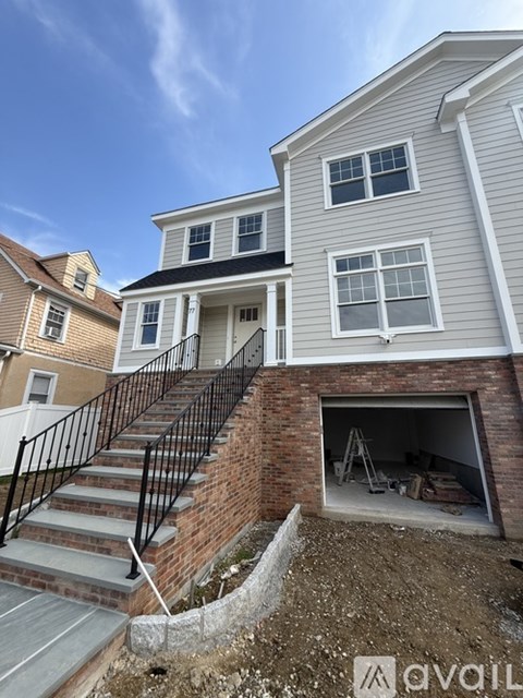 A house with a garage and a staircase leading to the entrance.