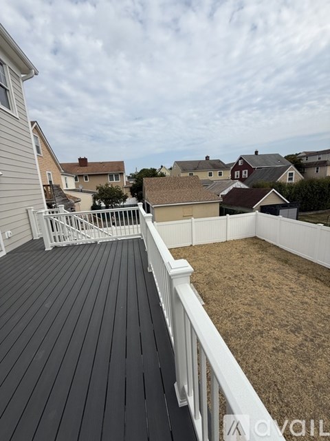 A house with a grey siding and a wooden deck.