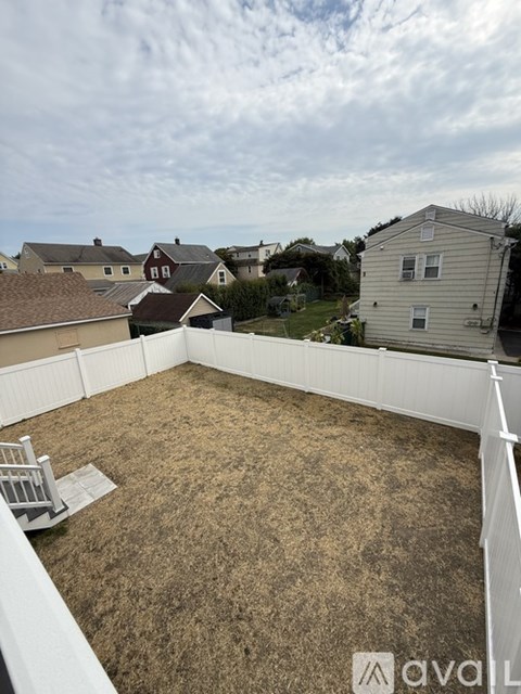 A white deck with a white railing and a white lawn mower.