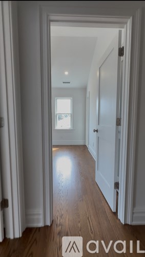 A long hallway with white shelves and a wooden floor.
