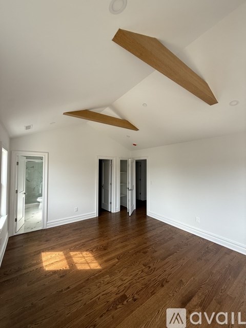 A glass shower door with a marble patterned wall.
