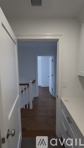 A bathroom with a sink, mirror, and a white tile floor.