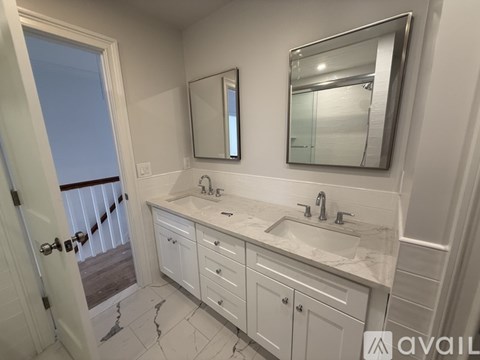 A bathroom with two sinks and a large mirror.
