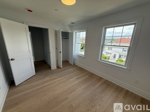 A room with a large window and wooden flooring.