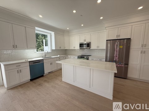 A kitchen with white cabinets and a large island.