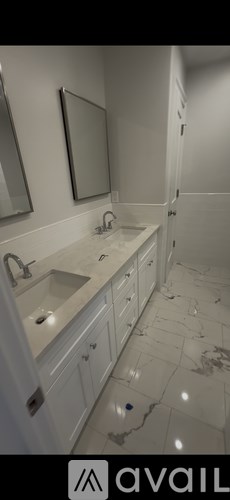 A room with wooden floors and white walls, with a window on the right side.