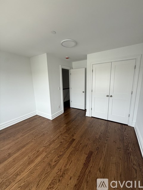 A long hallway with wooden floors and white walls.