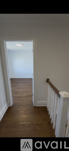 A room with a concrete floor and walls, and a door on the left side.