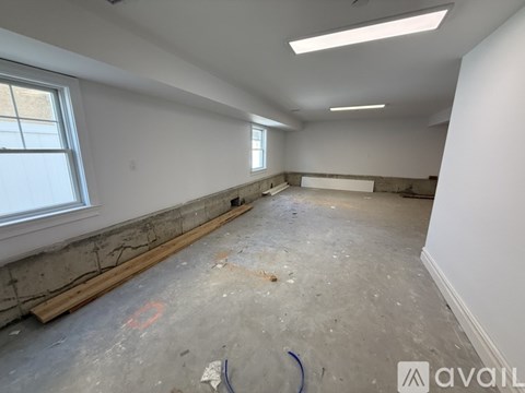 A room under construction with exposed concrete walls and a window.