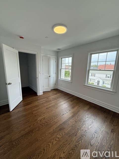 A large empty room with a concrete floor and white walls.