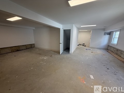 A large empty room with a doorway leading to another room.