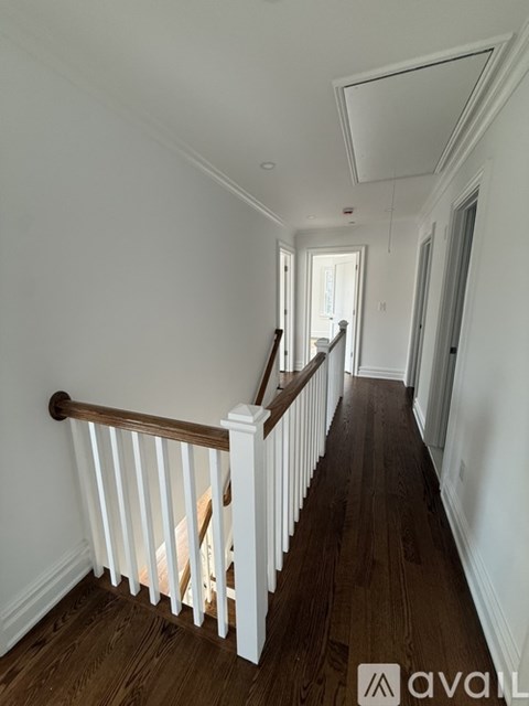 A patio with a wooden roof and brick flooring.