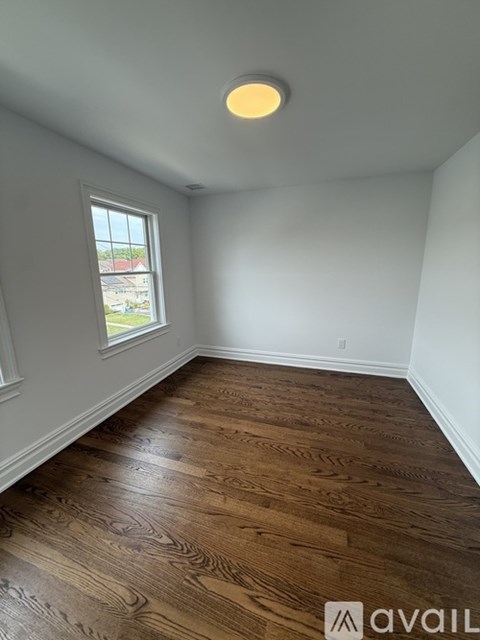 A room with wooden flooring and a window.